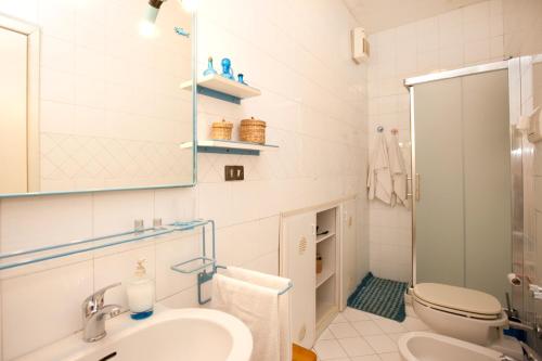 ein Badezimmer mit einem Waschbecken, einem WC und einem Spiegel in der Unterkunft Casa 12 B&B in Neapel