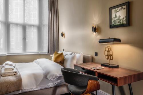a bedroom with a bed and a desk and a chair at The Knaresborough by Nestor in London