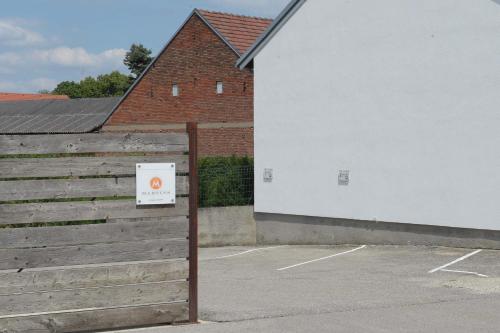 a fence with a sign on it next to a building at Weingut Martinshof in Sankt Ulrich