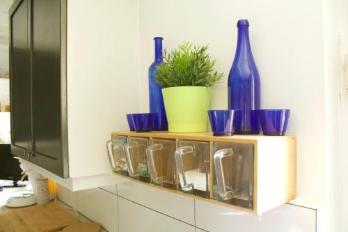 a shelf with blue glass bottles and a potted plant at La Lunadeléo in Wépion