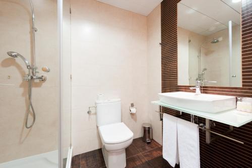 a bathroom with a toilet, sink, and shower at Hotel Mar e Sol & Spa in São Pedro de Moel