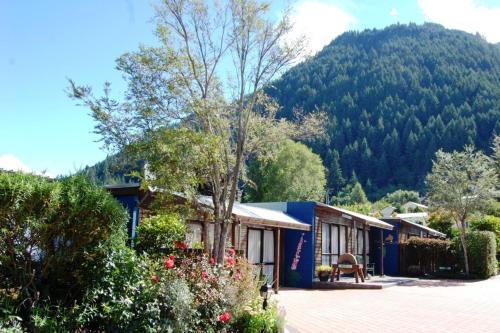 a house with a mountain in the background at Queenstown Holiday Park Creeksyde in Queenstown