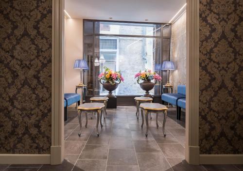 a waiting room with tables and chairs and a window at Hotel Torre Guelfa Palazzo Acciaiuoli in Florence