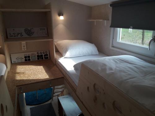 ein kleines Zimmer mit 2 Betten und einem Fenster in der Unterkunft Tiny House in Ootmarsum