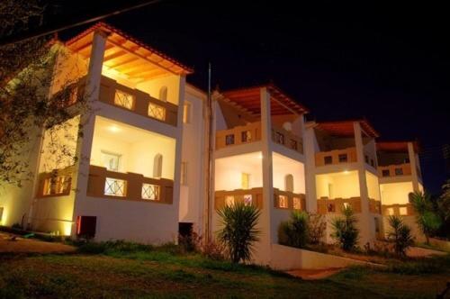 a large white house with its lights on at night at Elaionas in Leonidion