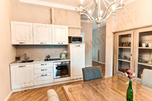 uma cozinha com armários brancos e uma mesa e cadeiras em Marconi 47 Suite em Bolonha