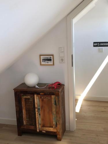 a room with a staircase and a table with a vase on it at Tor zum Meer in Helgoland