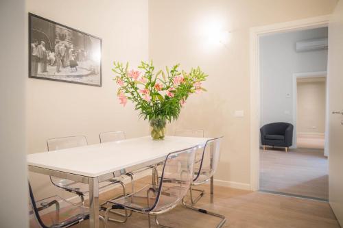 a dining room table with chairs and a vase of flowers at Hotel Torre Guelfa Palazzo Acciaiuoli in Florence