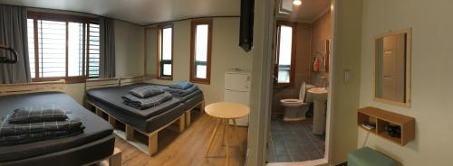 a small room with a bed and a bathroom at Take 1 Guesthouse Hongdae in Seoul