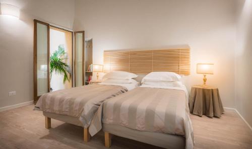 a bedroom with two beds and a table with lamps at Hotel Torre Guelfa Palazzo Acciaiuoli in Florence