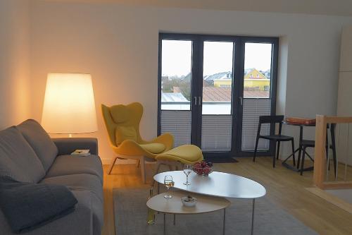 a living room with a couch and a table and chairs at Tor zum Meer in Helgoland
