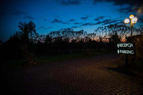 a sign that says kreczko i parking at night at Lodownia in Szydłowiec