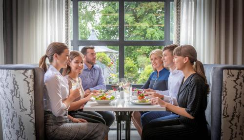 a group of people sitting around a table eating food at Castletroy Park Hotel in Limerick