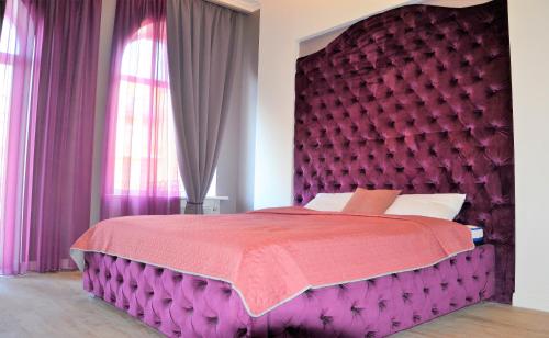 um quarto com uma cama grande e uma cabeceira de cama roxa em Kiev City Center em Kiev