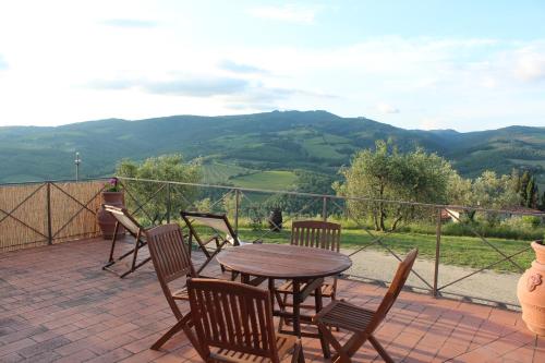 a table and chairs on a patio with mountains in the background at Tenuta il Poggetto in Radda in Chianti