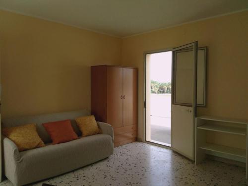 - un salon avec un canapé et une porte coulissante en verre dans l'établissement Monolocale Rosina, à Trapani