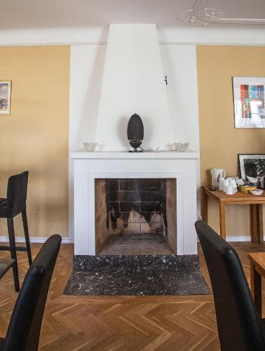 a living room with a fireplace with two chairs at Södra Hotellet in Norrköping