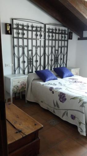a bedroom with a bed with blue pillows and a table at Lagar II con Jacuzzi in Curiel de Duero