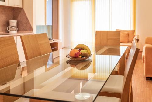 a glass table with a bowl of fruit on it at Garden of Eden Complex in Sveti Vlas