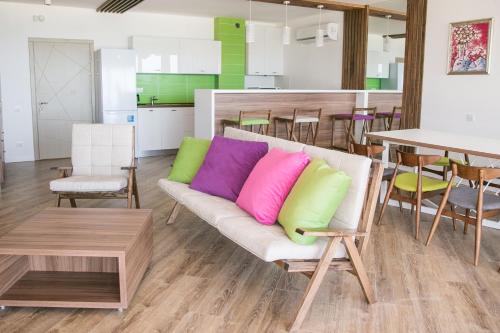 a living room with a couch with colorful pillows on it at Villa RK DeLuxe in Zatoka