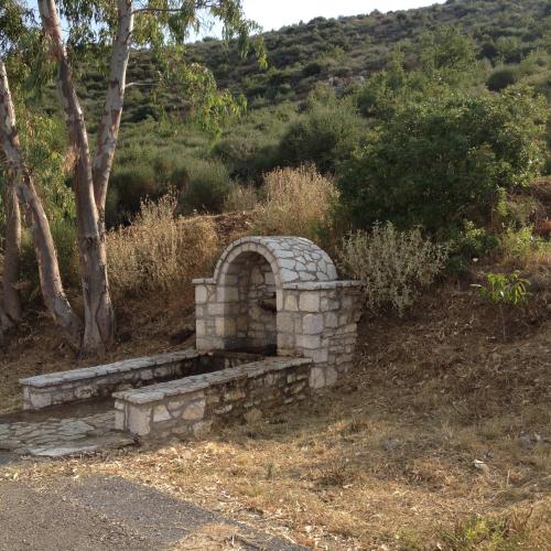 a stone fireplace sitting on the side of a road at Gourgiana Apartments in Andritsaina