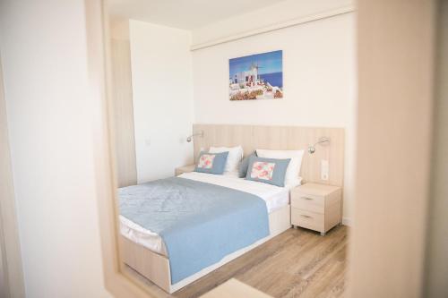 a small bedroom with a bed and a mirror at Villa RK DeLuxe in Zatoka
