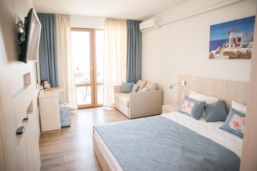 a bedroom with a bed and a couch in a room at Villa RK DeLuxe in Zatoka
