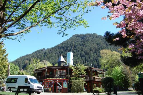 a van parked in front of a building with a mountain at Queenstown Holiday Park Creeksyde in Queenstown