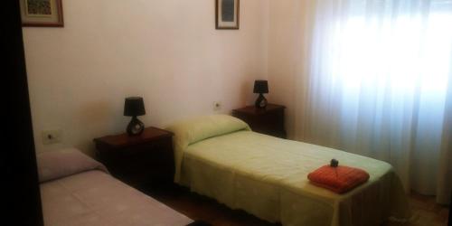 1 dormitorio con 2 camas individuales y ventana en Casa Cuche, en Ourense