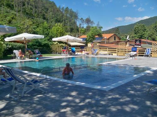 a man is in a swimming pool at Villaggio Camping Valdeiva in Deiva Marina