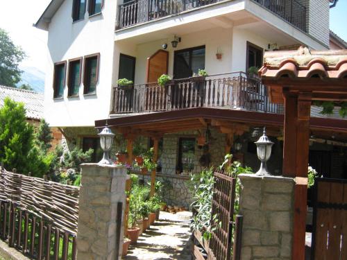 a house with a balcony and a fence at Risto's Guest House in Ohrid