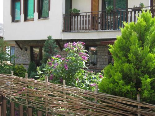 a fence in front of a house with flowers at Risto's Guest House in Ohrid