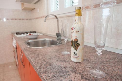赫瓦尔Apartments Majić的一瓶葡萄酒和两杯酒杯坐在柜台上
