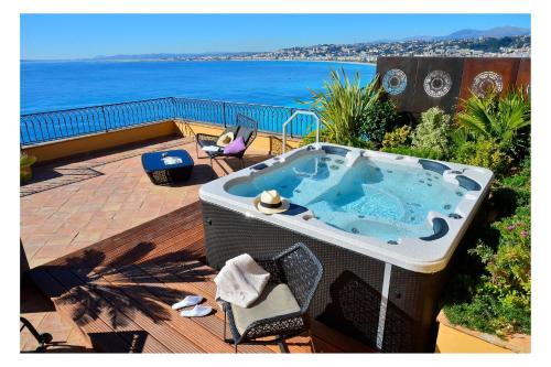 a hot tub on a deck with a view of the ocean at Hôtel La Pérouse Nice Baie des Anges in Nice