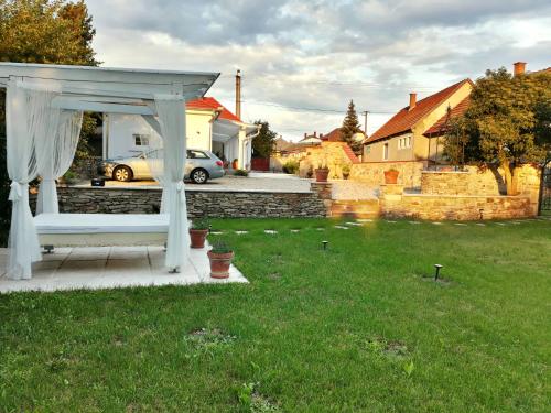 a white gazebo in the yard of a house at Vidéki Varázs Vendégház in Bogács