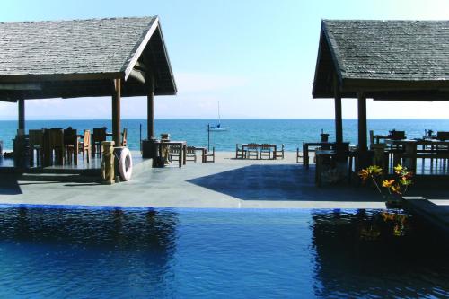 a swimming pool with a view of the ocean at Cafe Alberto B and B in Senggigi 