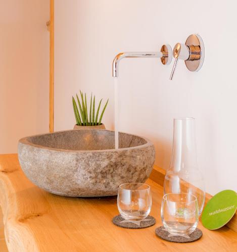 a bowl sink on a wooden table with two glasses at Das Wistlberg Wohlfühlchalet in Mauth