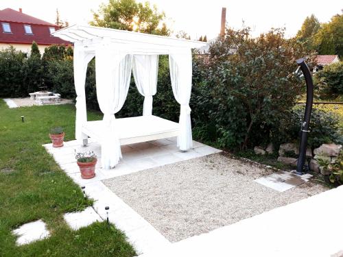 a white gazebo in the middle of a yard at Vidéki Varázs Vendégház in Bogács
