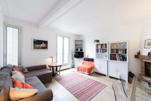 sala de estar con sofá y chimenea en Veeve - Contemporary in Balard en París