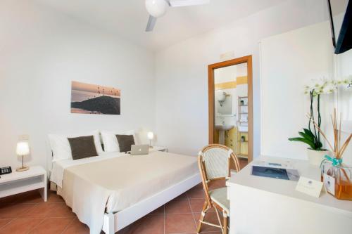 a white bedroom with a bed and a table at Il Cefalo Hotel & Restaurant in Castellabate