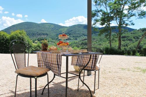 a table with a plate of food on it with two chairs at Agriturismo Le Catre in Castagneto Carducci
