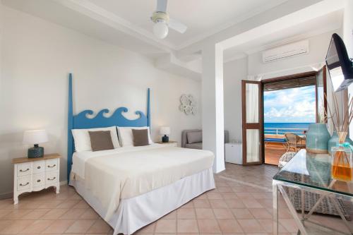 a bedroom with a bed and a view of the ocean at Il Cefalo Hotel & Restaurant in Castellabate