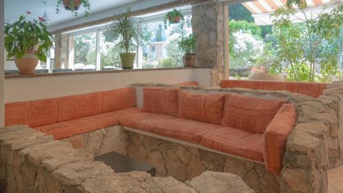 a large stone couch in a room with windows at Hotel des Etrangers in Bonifacio