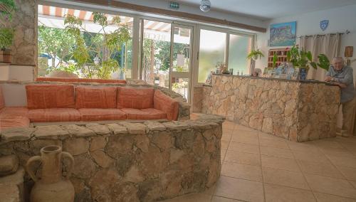 a living room with a stone wall and a couch at Hotel des Etrangers in Bonifacio
