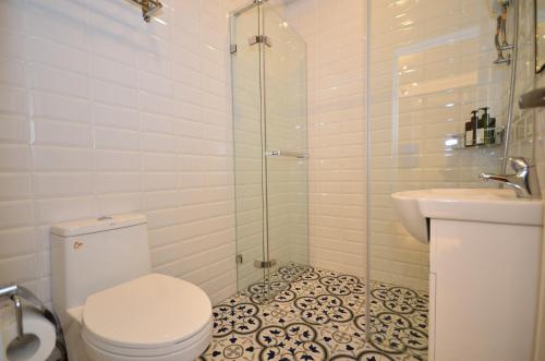 a bathroom with a toilet and a shower and a sink at Lè mù in Taichung
