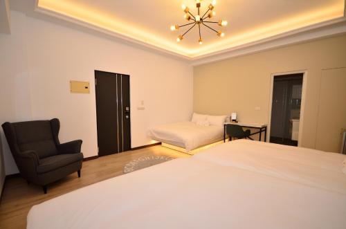 a bedroom with a bed and a chair and a bed and a couch at Lè mù in Taichung