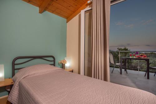 a bedroom with a bed and a balcony with a view at Villa Antonio in Romírion