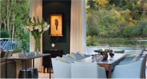 a living room with white furniture and a large window at Huka Lodge in Taupo