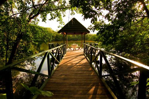 a wooden bridge over a body of water with a gazebo at Las Lagunas Boutique Hotel in Flores