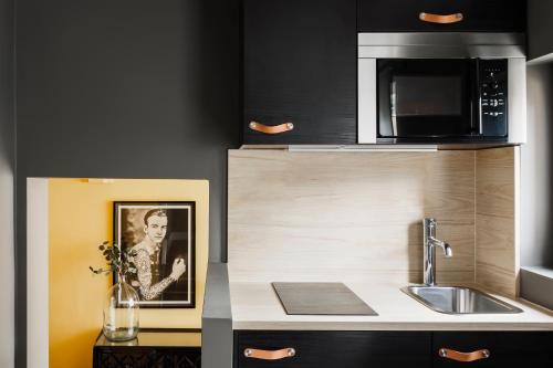 a kitchen with a sink and a microwave at The Knaresborough by Nestor in London